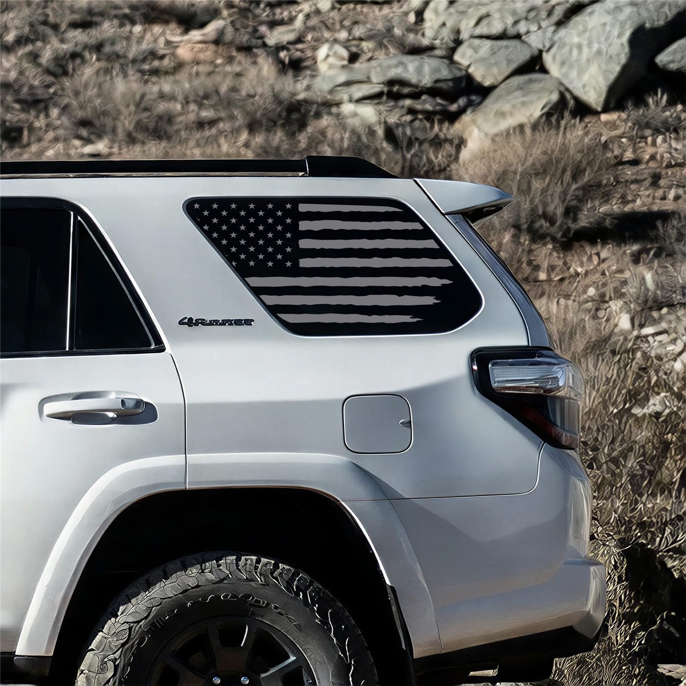 Distressed American flag decal on the rear quarter window of a silver Toyota 4Runner