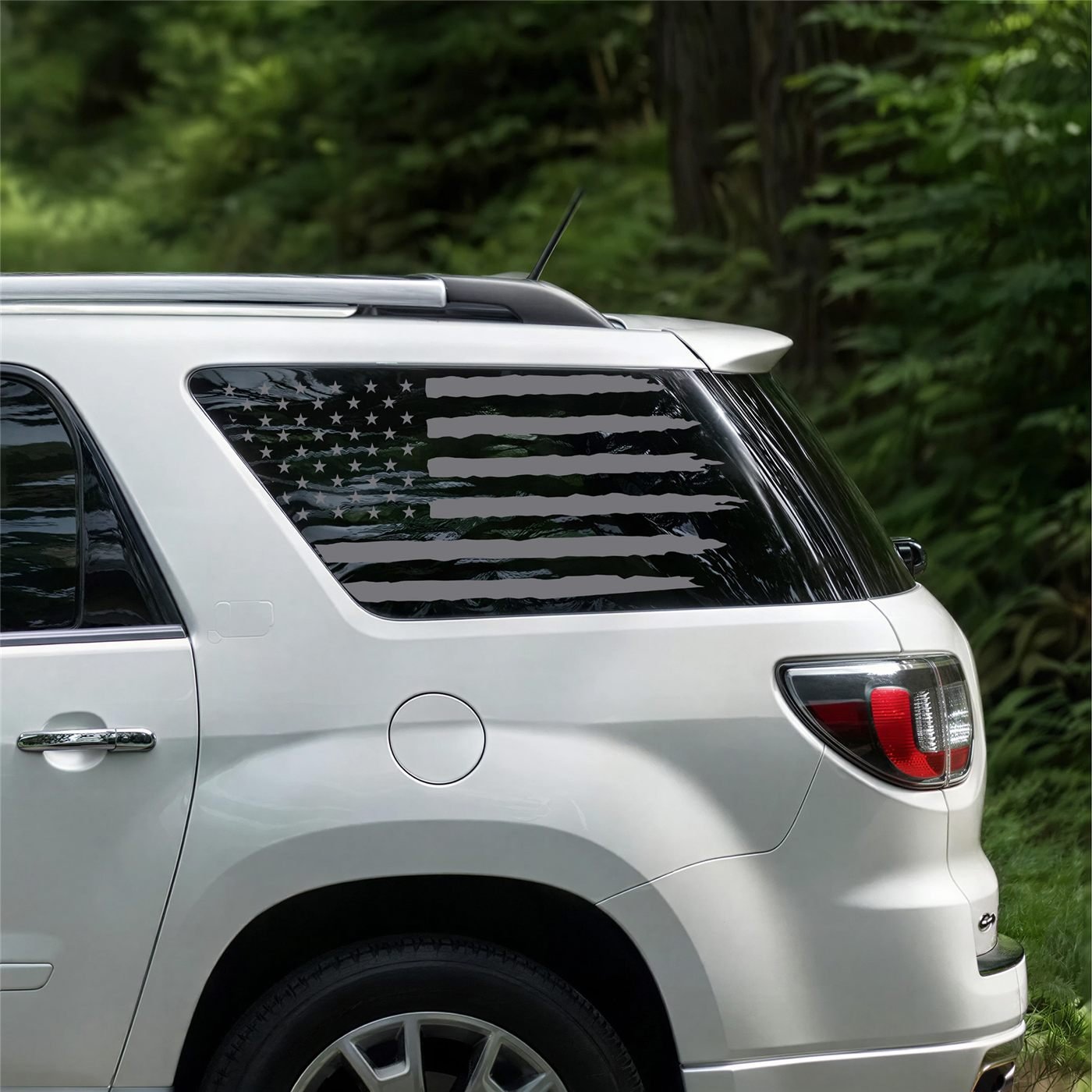 Distressed American flag decal on the rear quarter window of a white GMC Acadia