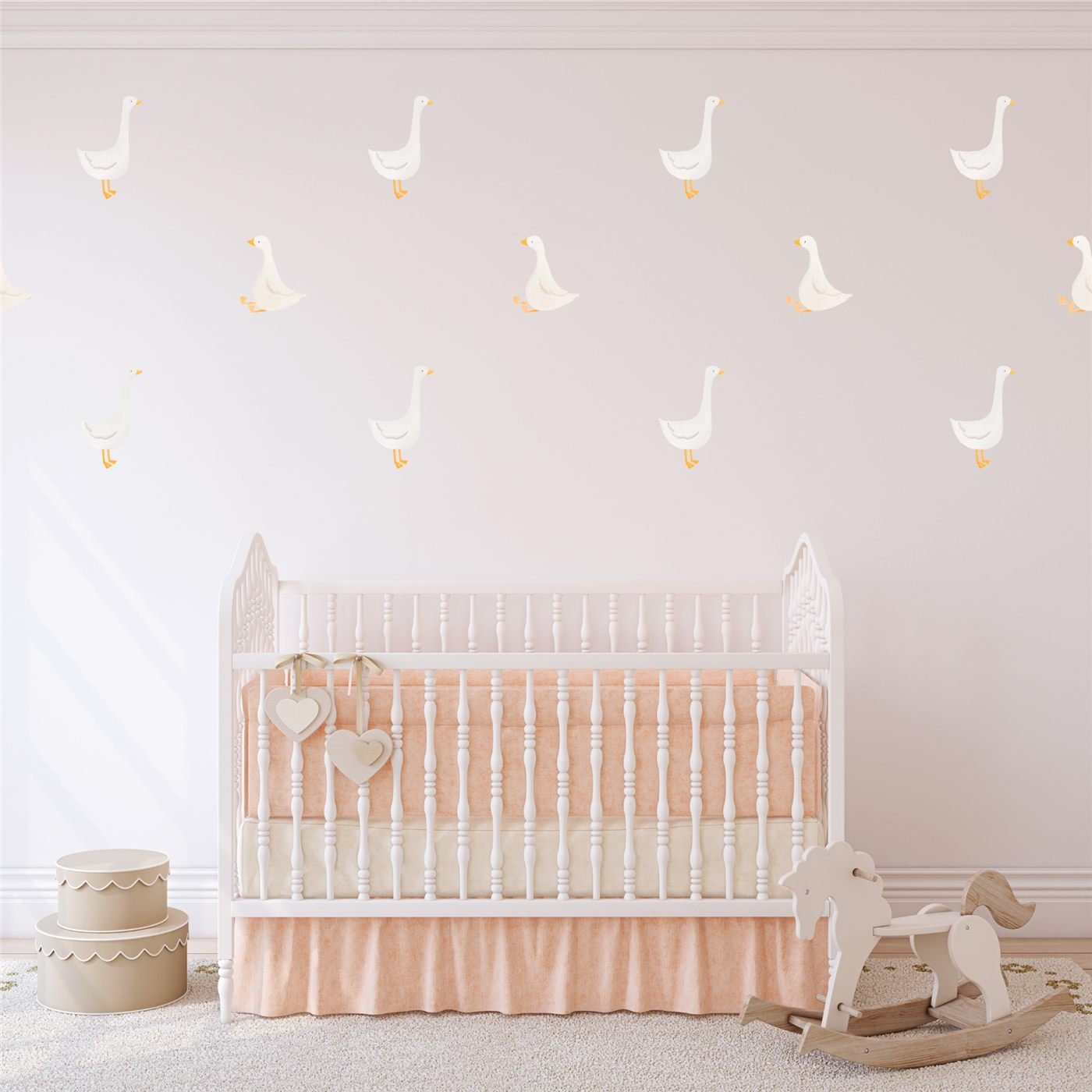 White silly goose wall decals arranged above a crib in a soft pink nursery